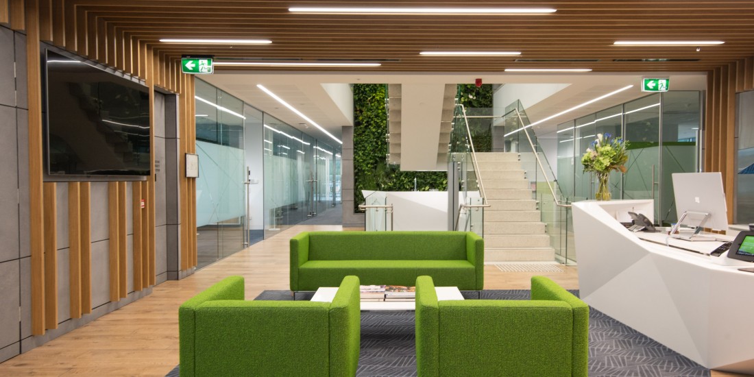 Building reception area looking towards floating staircase and green wall
