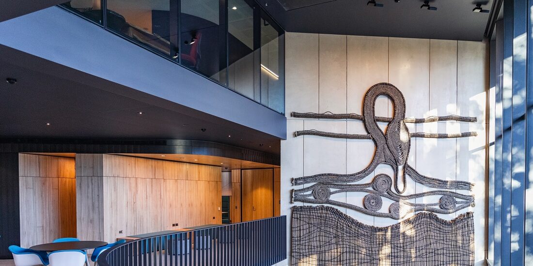 Building foyer with large Indigenous artwork on interior wall